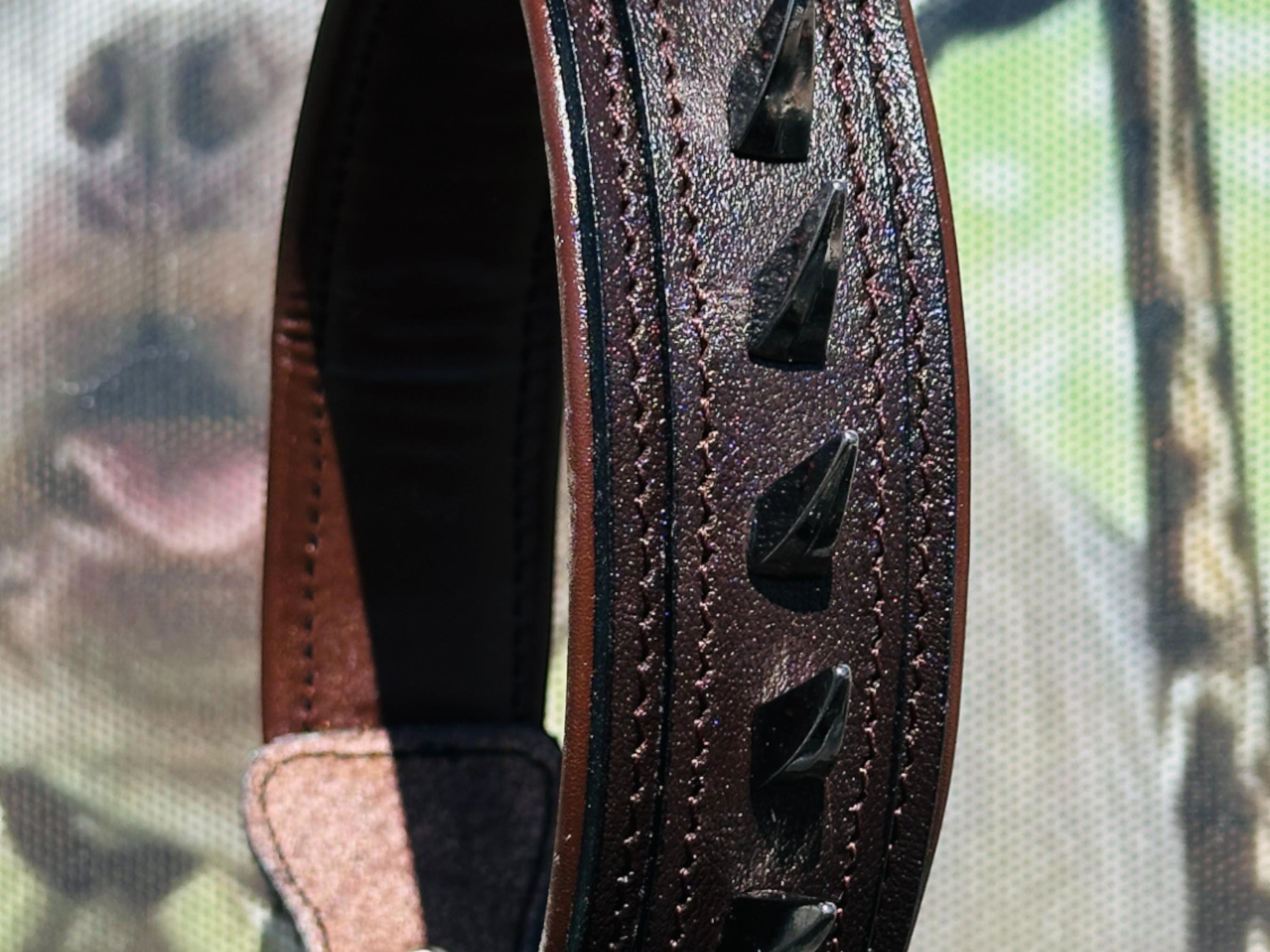 Handmade brown leather dog collar with spikes and lion head emblem by A&C Dog Collars, showing the detailed design and sturdy buckle.